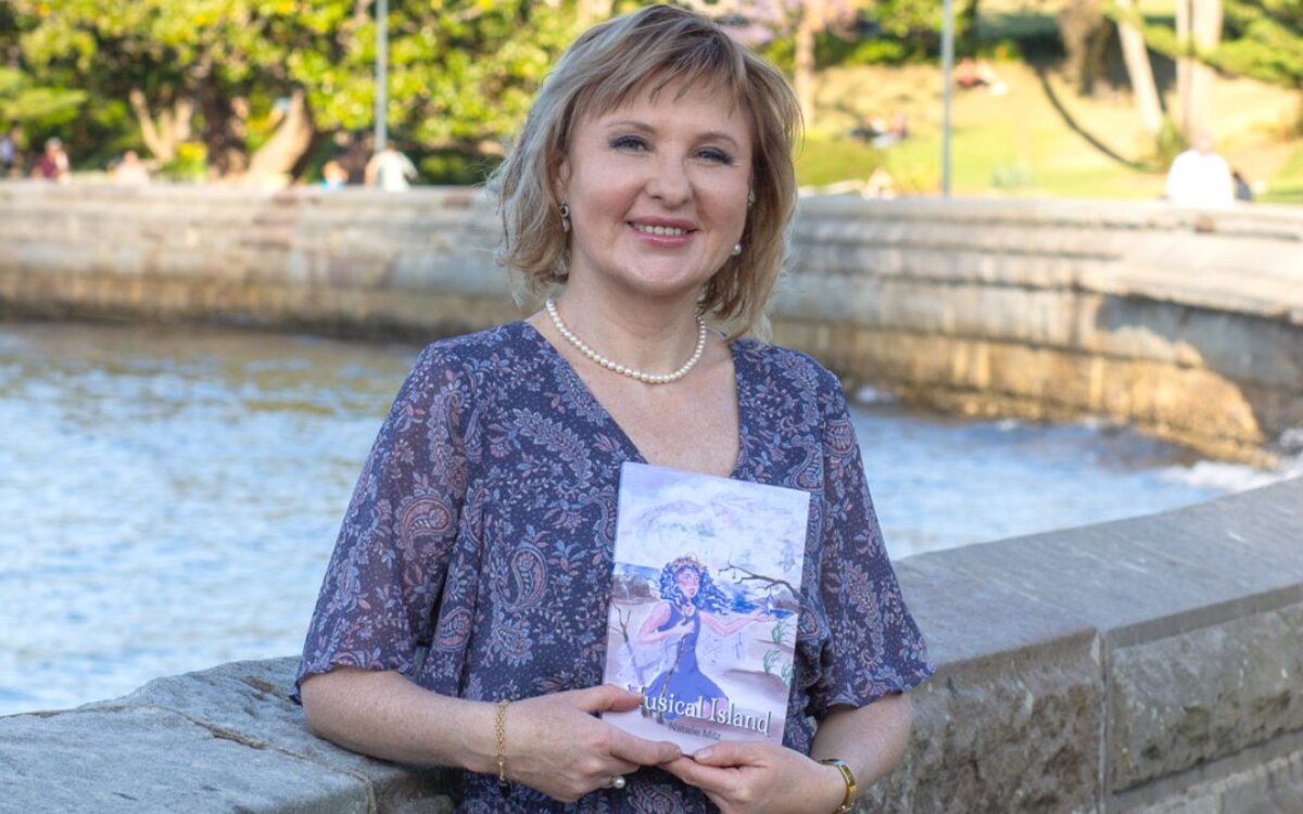 Natalie Mitz holding her children's book, Musical Island